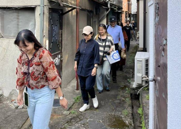 Guests on a lunch and coffee tour walking through the streets of Beppu.